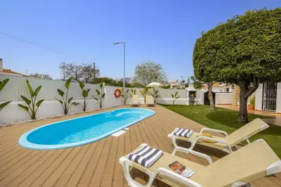 a swimming pool on a deck with lounge chairs at Villa Lela by Villa Plus in Albufeira