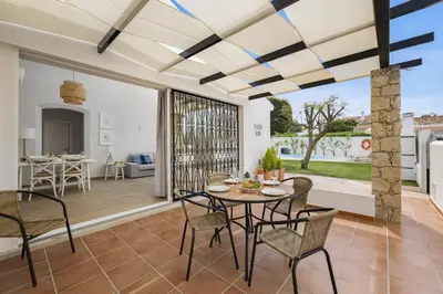 a dining room with a table and chairs on a deck at Villa Lela by Villa Plus in Albufeira