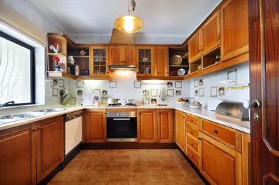 a large kitchen with wooden cabinets and a window at Villa Verao Sol by Villa Plus in Albufeira