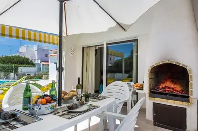 a patio with a fireplace and a table and chairs at Villa Verao Sol by Villa Plus in Albufeira
