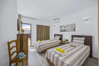 a hotel room with two beds and a television at Villa Pina by Villa Plus in Albufeira
