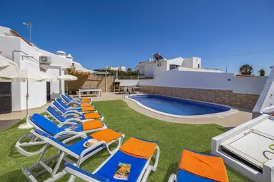 a white room with a bed and a chair at Villa Pina by Villa Plus in Albufeira