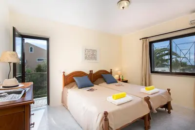 a bedroom with a bed and a large window at Villa Tupi by Villa Plus in Boliqueime