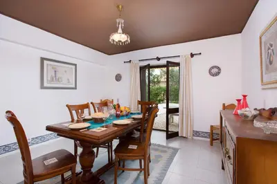 a dining room with a wooden table and chairs at Villa Tupi by Villa Plus in Boliqueime