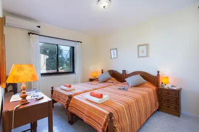 a bedroom with two beds and a table with a lamp at Villa Tupi by Villa Plus in Boliqueime