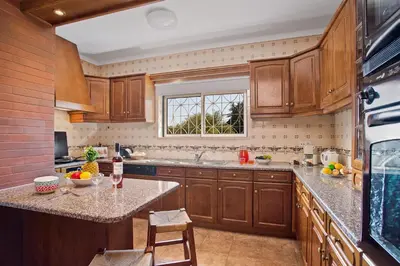 a kitchen with wooden cabinets and a window at Villa Boavista by Villa Plus in Boliqueime
