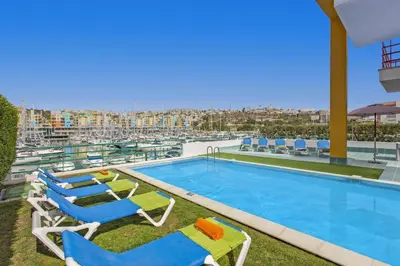 a swimming pool with lounge chairs and a view of a city at Villa Marina View by Villa Plus in Albufeira