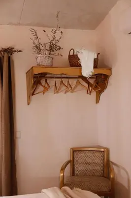 a bedroom with a chair and a shelf on the wall at Casa Rústica em Alte - KARMEA HOUSES in Alte