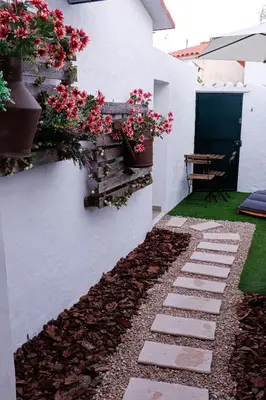 a garden with flowers on the side of a house at Casa Rústica em Alte - KARMEA HOUSES in Alte