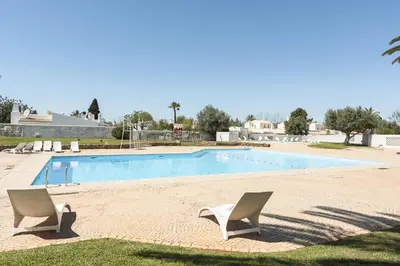 two chairs sitting in front of a swimming pool at Aldeia do Golfe - Private condominium by HD in Vilamoura