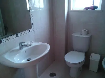 a white bathroom with a toilet and a sink at Remarkable 1-Bed Apartment in Olhos de Agua in Albufeira
