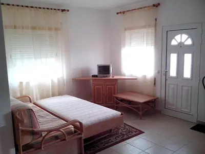 a bedroom with a bed and a desk and a door at Remarkable 1-Bed Apartment in Olhos de Agua in Albufeira