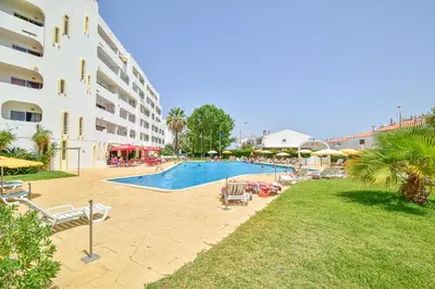 a swimming pool next to a large building at SouthView Studio Silchoro AL in Albufeira