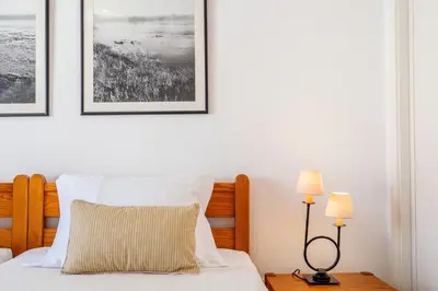 a bedroom with a bed with two pictures on the wall at Ténis Mar F in Albufeira