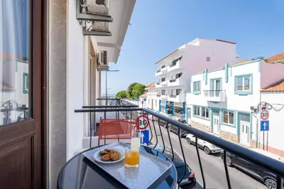 a table with a drink and donuts on a balcony at Ténis Mar F in Albufeira