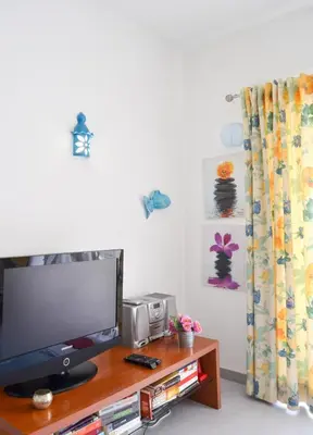 a living room with a television on a wooden table at BeGuest Feliz Choro Apartment in Branqueira