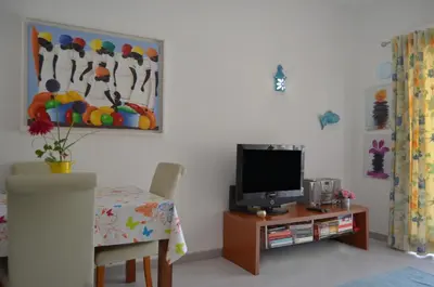 a living room with a tv and a table at BeGuest Feliz Choro Apartment in Branqueira