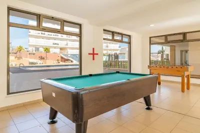 a pool table in a room with a window at Solário de São José - AD by HelloVacations in Albufeira