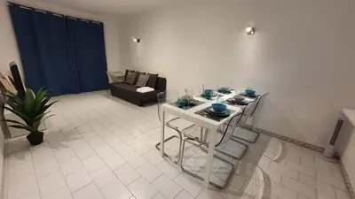 a living room with a table and chairs and a couch at BeGuest Areias Apartment in Albufeira