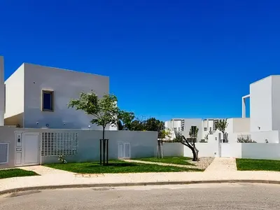 a white house with a tree in front of it at FLH Vilamoura Duplex with Terrace & Pool in Vilamoura