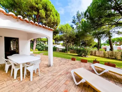 a patio with a white table and benches at FLH Balaia House with Terrace in Albufeira