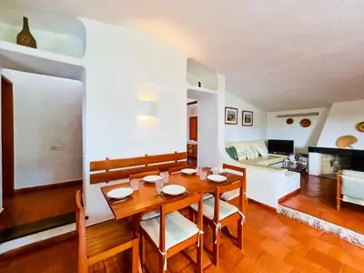 a kitchen and dining room with a wooden table and chairs at FLH Balaia House with Terrace in Albufeira