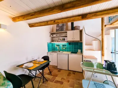 a small kitchen with a table and chairs in a room at FLH Vale Judeu Rustic Mezzanine Cottage II in Loulé