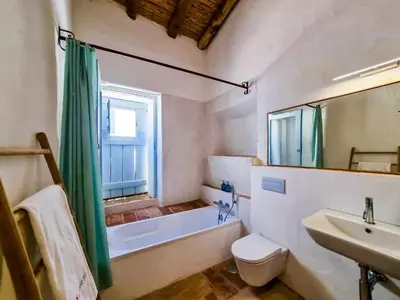 a bathroom with a tub and a toilet and a sink at FLH Vale Judeu Rustic Mezzanine Cottage II in Loulé