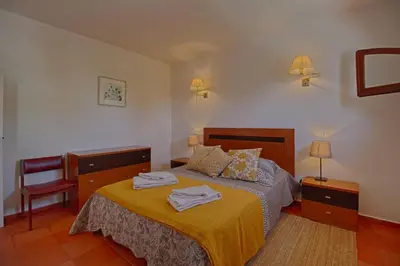 a bedroom with a bed with two towels on it at Apartamento Olhos D'Água VistaBella in Olhos de Água