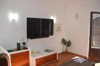 a living room with a flat screen tv on the wall at Apartamento Olhos D'Água VistaBella in Olhos de Água