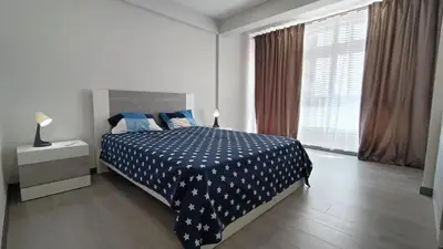 a bedroom with a bed with a blue blanket with stars at New Appartment! Albufeira in Albufeira