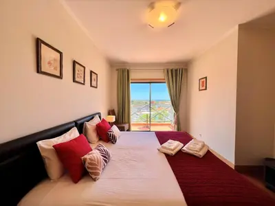 a bedroom with a large bed with red and white pillows at Albufeira Modern 2 With Pool by Homing in Albufeira