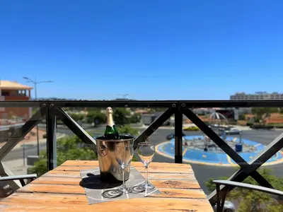 a table with a bottle of wine and two glasses at Albufeira Modern 2 With Pool by Homing in Albufeira