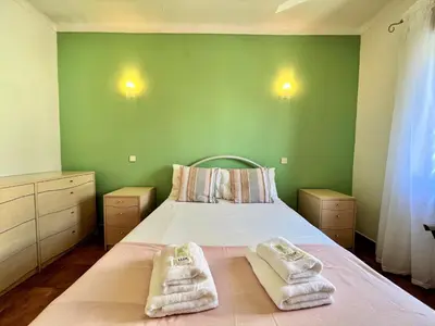 a green bedroom with a bed with towels on it at Albufeira Classic 2 by Homing in Albufeira