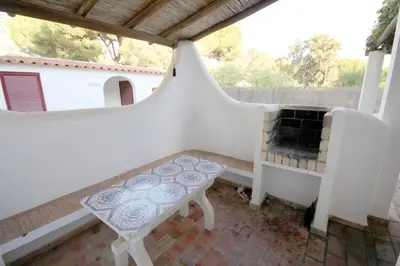 a small balcony with a bench and a table at Villa Dantas by amcf in Vilamoura