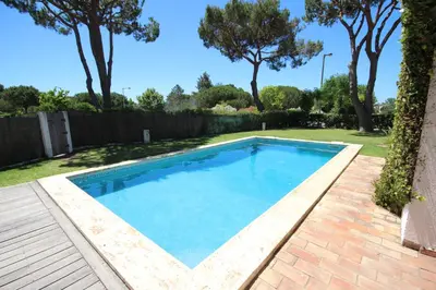 a swimming pool in a yard with trees at Villa Dantas by amcf in Vilamoura