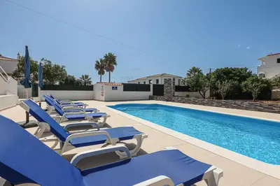 a row of blue lounge chairs next to a swimming pool at Apart Quinta dos Martins - swimming pool - BY BEDZY in Albufeira