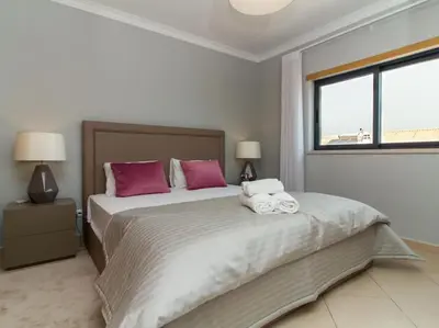 a bedroom with a large bed with pink and white pillows at Magnólia O House by Stay ici Algarve Holiday Rental in Albufeira