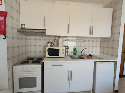 a small kitchen with white cabinets and a microwave at Endless Summer in Albufeira