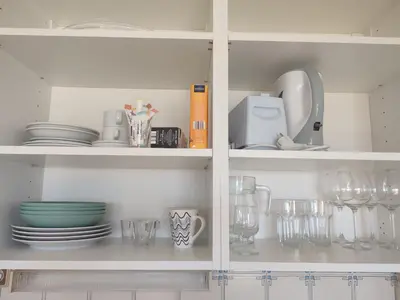 a white cabinet with plates and cups and dishes at Endless Summer in Albufeira