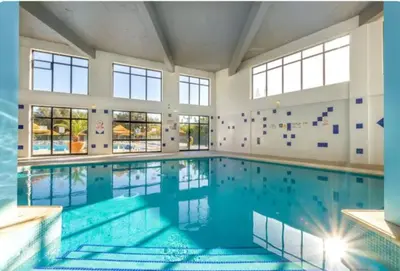 a large indoor swimming pool with blue water at Endless Summer in Albufeira