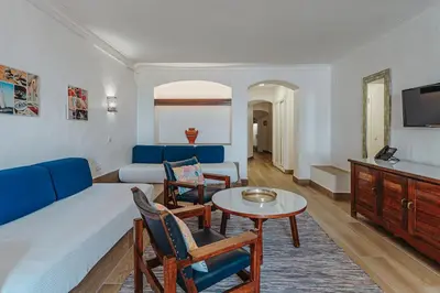 a living room with a couch and a table and chairs at Apartamentos Borda D´Agua in Albufeira