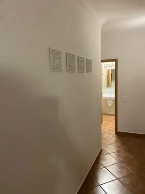 a room with a white wall with three pictures on it at Parra Home Holidays - Close to Galé Beach in Guia