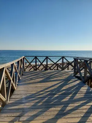 a wooden pier with the ocean in the background at Quinta do Lago Golf, Sea & Sun in Quinta do Lago
