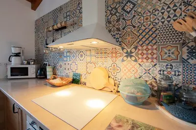 a kitchen with a counter top with tiles on the wall at Cosy Farmhouse Quinta da Eira 140 years old in Loulé