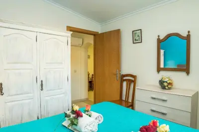 a bedroom with a blue table with a dresser and a mirror at T1 Anastacio in Albufeira