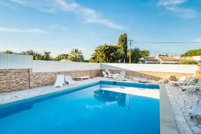 a swimming pool with blue water in a backyard at T1 Anastacio in Albufeira