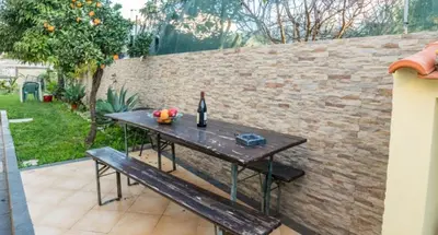 a wooden table with a bottle of wine and a bench at T1 Anastacio in Albufeira