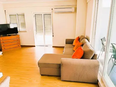 a living room with a couch and a television at Flat 3 Bedrooms Albufeira in Albufeira