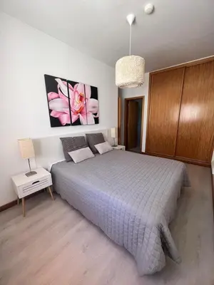 a bedroom with a bed and a pink flower on the wall at Joyful Marina - Albufeira in Albufeira